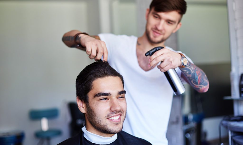 Man spraying client's hair