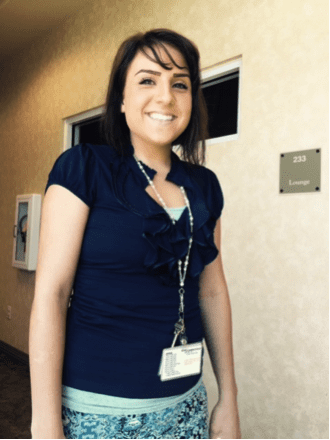 Woman smiling at camera wearing a name tag
